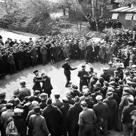 Russische Zwangsarbeiter, die von den einmarschierenden Truppen der 9. Amerikanischen Armee befreit wurden, feiern vor ihren Baracken in Klotze den 1. Mai 1945 in Freiheit.