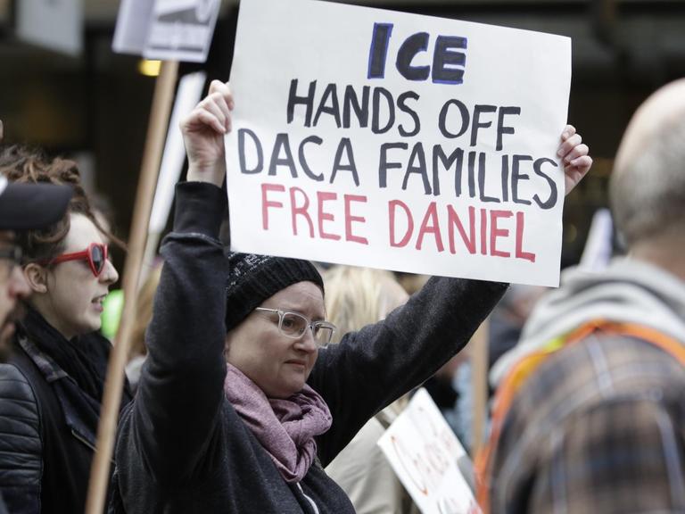 Eine Demonstrantin hält ein Schild in der Hand mit der Aufschrift: "ICE - Hands off Daca-families, free Daniel"
