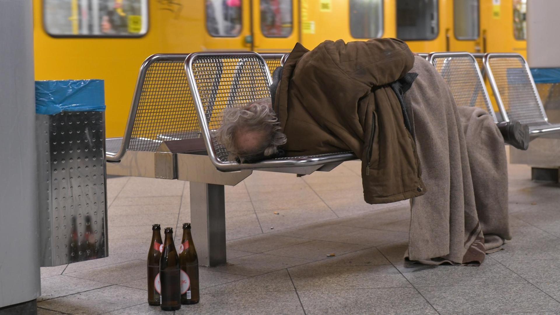 Ein Mann schläft auf einer Bank in einer U-Bahn-Station in Berlin. Ein Mann schläft auf einer Bank in einer U-Bahn-Station in Berlin.