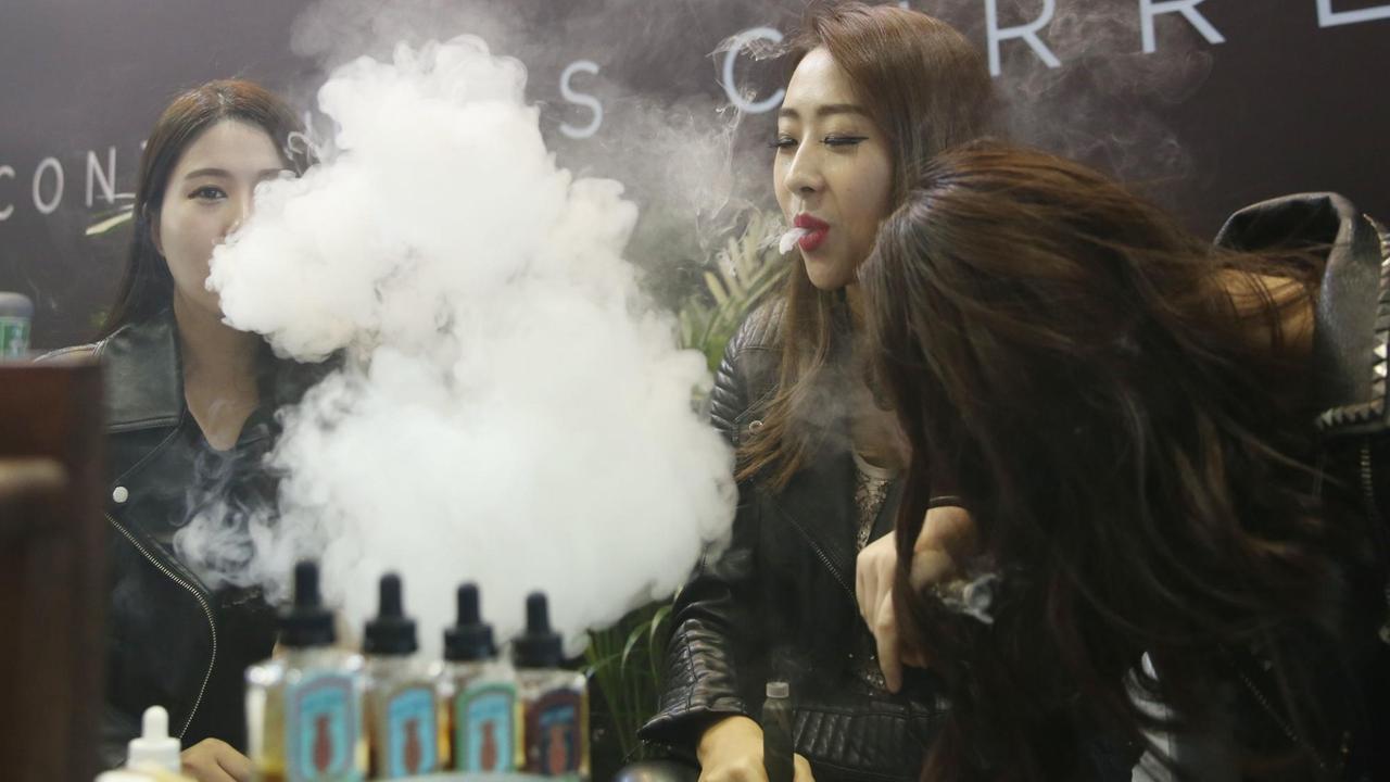 Showgirls rauchen eine E-Zigarette anlässlich der 4. China International E-Cig/Vape Expo in Peking.