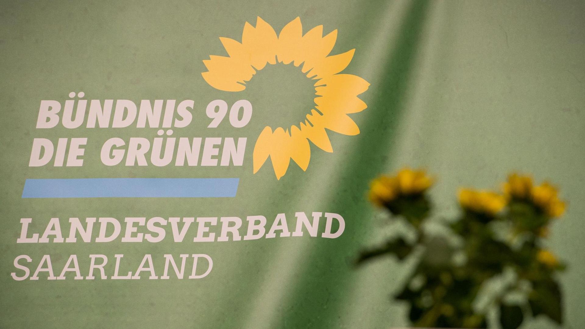 Das Logo des Landesverbandes Saarland Bündnis 90/Die Grünen ist auf einem Transparent auf der der Bühne des Landesparteitages zu sehen