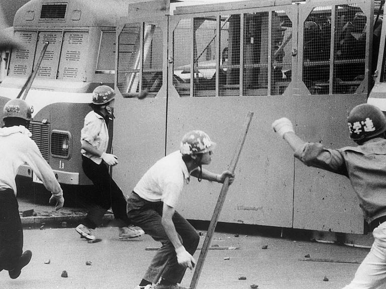 Japanische Studenten werfen am 1.8.1968 Steine auf Fahrzeuge der Polizei am Eingang des Flughafens in Tokio