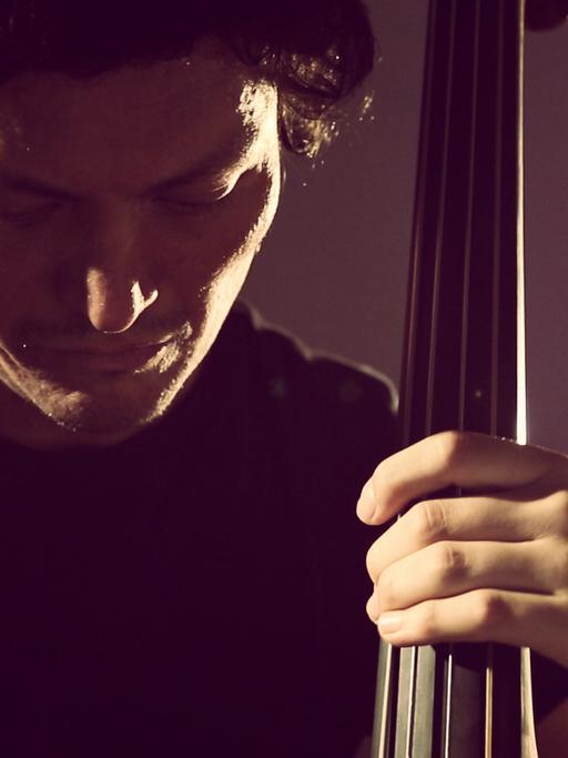 Der Musiker Matthias Akeo Nowak spielt am Kontrabass.