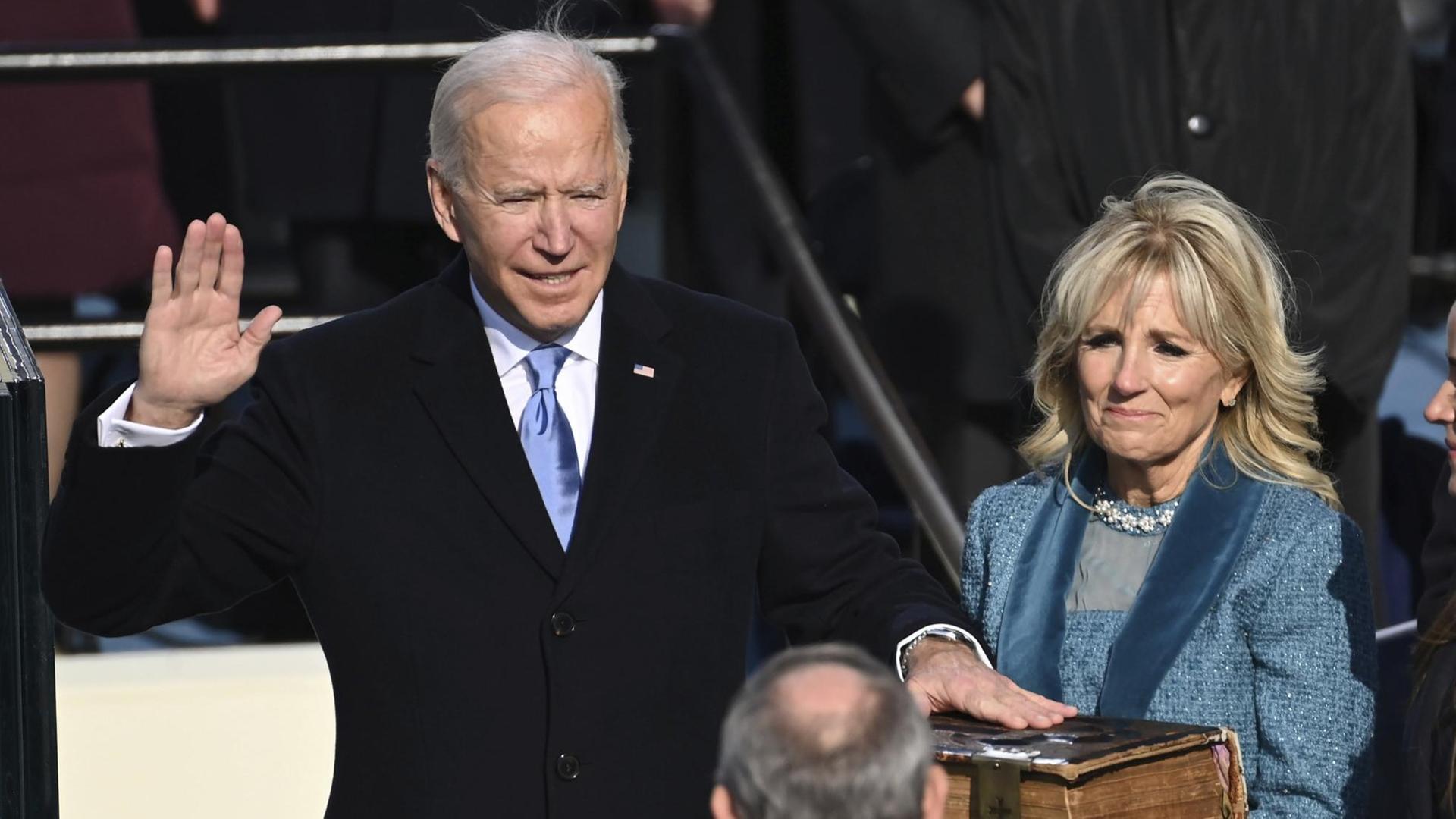 Joe Biden wird als US-Präsident vereidigt und schwört auf die Bibel, rechts von ihm steht seine Ehefrau.