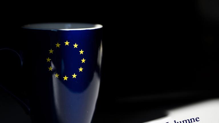 Eine Kaffeetasse in den Farben der Europaflagge