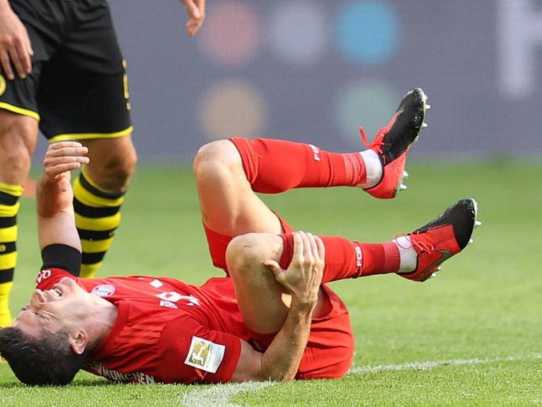 Der Fussballspieler Robert Lewandoski vom FC Bayern München liegt nach einem Foul von Łukasz Piszczek (Borussia Dortmund) am Boden. Der Fussballspieler Robert Lewandoski vom FC Bayern München liegt nach einem Foul von Łukasz Piszczek (Borussia Dortmund) am Boden.