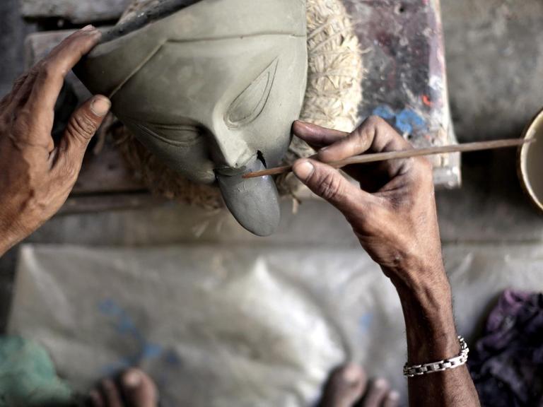 Ein indischer Tonkünstler arbeitet an einer Figur der Göttin Kali.