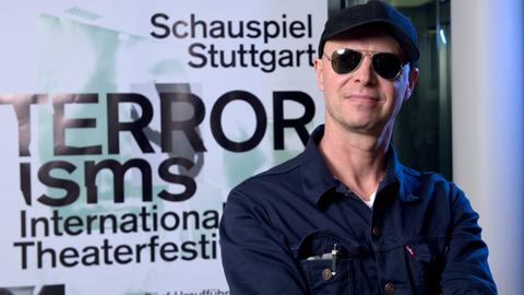 Armin Petras, Intendant des Schauspiels Stuttgart, steht am 18.06.2015 im Schauspiel in Stuttgart vor einem Plakat für das Theaterfestival "TERRORisms / Terrorismen".