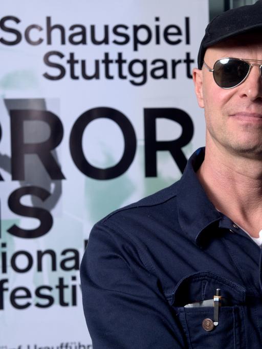 Armin Petras, Intendant des Schauspiels Stuttgart, steht am 18.06.2015 im Schauspiel in Stuttgart vor einem Plakat für das Theaterfestival "TERRORisms / Terrorismen".