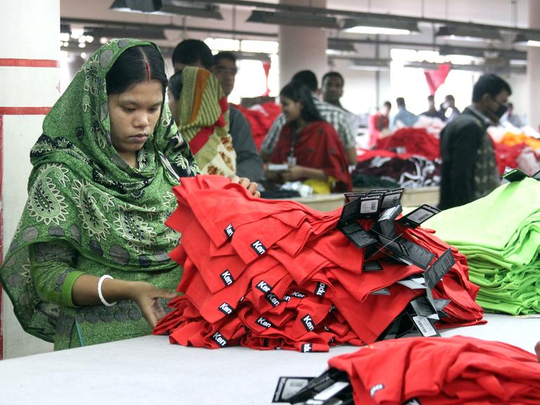 Frauen und Männer arbeiten am 03.01.2014 in der Textilfabrik "One Composite Mills" in Gazipur, einem Vorort der Hauptstadt Dhaka in Bangladesch.