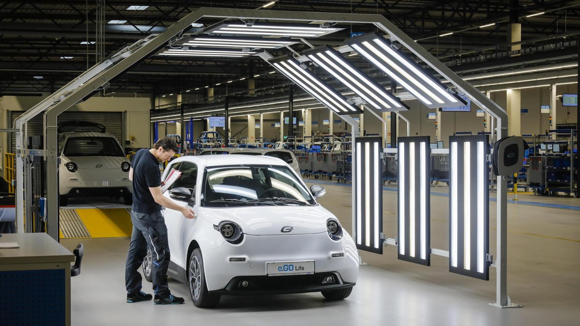 Ein Mitarbeiter bei der Endkontrolle eines e.GO Life Elektroautos in der Montagehalle in Aachen