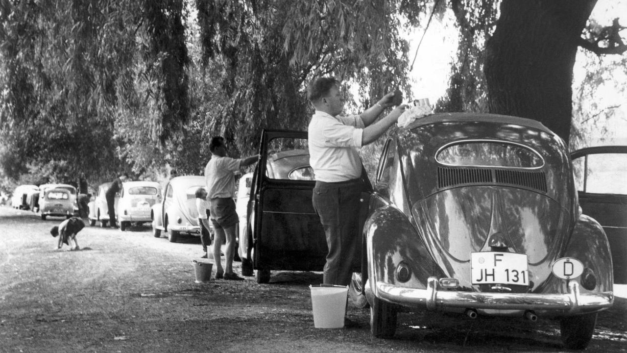 Am Samstag fährt der ordentliche Mann zur Autowäsche mit seinem Wagen an das nächstgelegene Gewässer, wie hier im Jahr 1960. Nicht jeder Autobesitzer ist gewillt oder in der Lage, Geld für eine Reinigung des "liebsten Kindes" zu bezahlen. Foto: Willi Gutberlet +++(c) dpa - Report+++