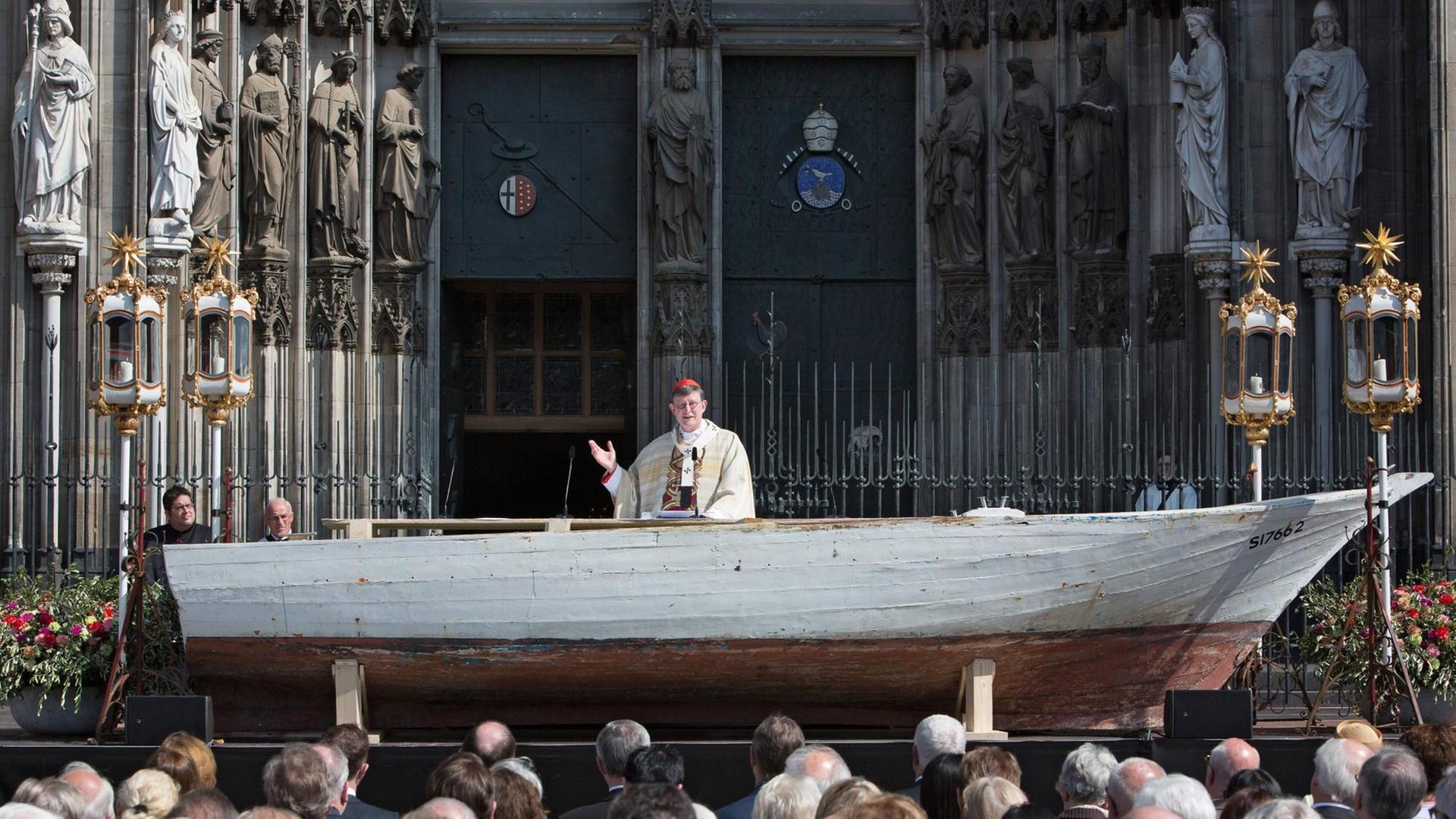 Kardinal Rainer Woelki feiert die Fronleichnam Messe. Ein Flüchtlingsboot dient als Altar.