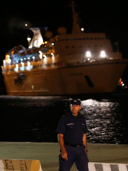 Ein zyprischer Polizist patrouilliert vor dem Kreuzfahrtschiff "Salamis Filoxenia", das syrische Flüchtlinge aus Seenot im Mittelmeer gerettet hatte.