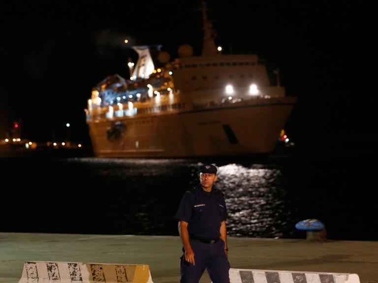 Ein zyprischer Polizist patrouilliert vor dem Kreuzfahrtschiff "Salamis Filoxenia", das syrische Flüchtlinge aus Seenot im Mittelmeer gerettet hatte.
