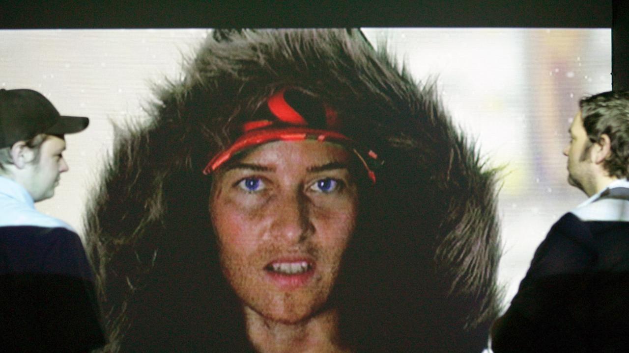 Zwei Ausstellungsbesucher betrachten eine Videoinstallation von Stefan Panhans mit dem Titel "Sieben bis zehn Millionen". Im Vordergrund steht eine Person mit Winterfellkapuzenjacke. Zwei Ausstellungsbesucher betrachten eine Videoinstallation von Stefan Panhans mit dem Titel "Sieben bis zehn Millionen". Im Vordergrund steht eine Person mit Winterfellkapuzenjacke.