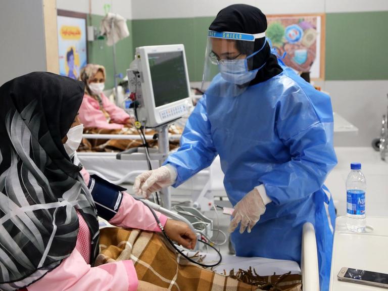 Im grössten Einkausfszentrum in Teheran, der "Iranmall", ist ein Krankenhaus für Coronapatienten entstanden. Hier wird eine Patientin von einer Krankenpflegerin versorgt. Beide tragen Kopftuch und Mundschutz. Teheran, 30. März 2020, Iran.
