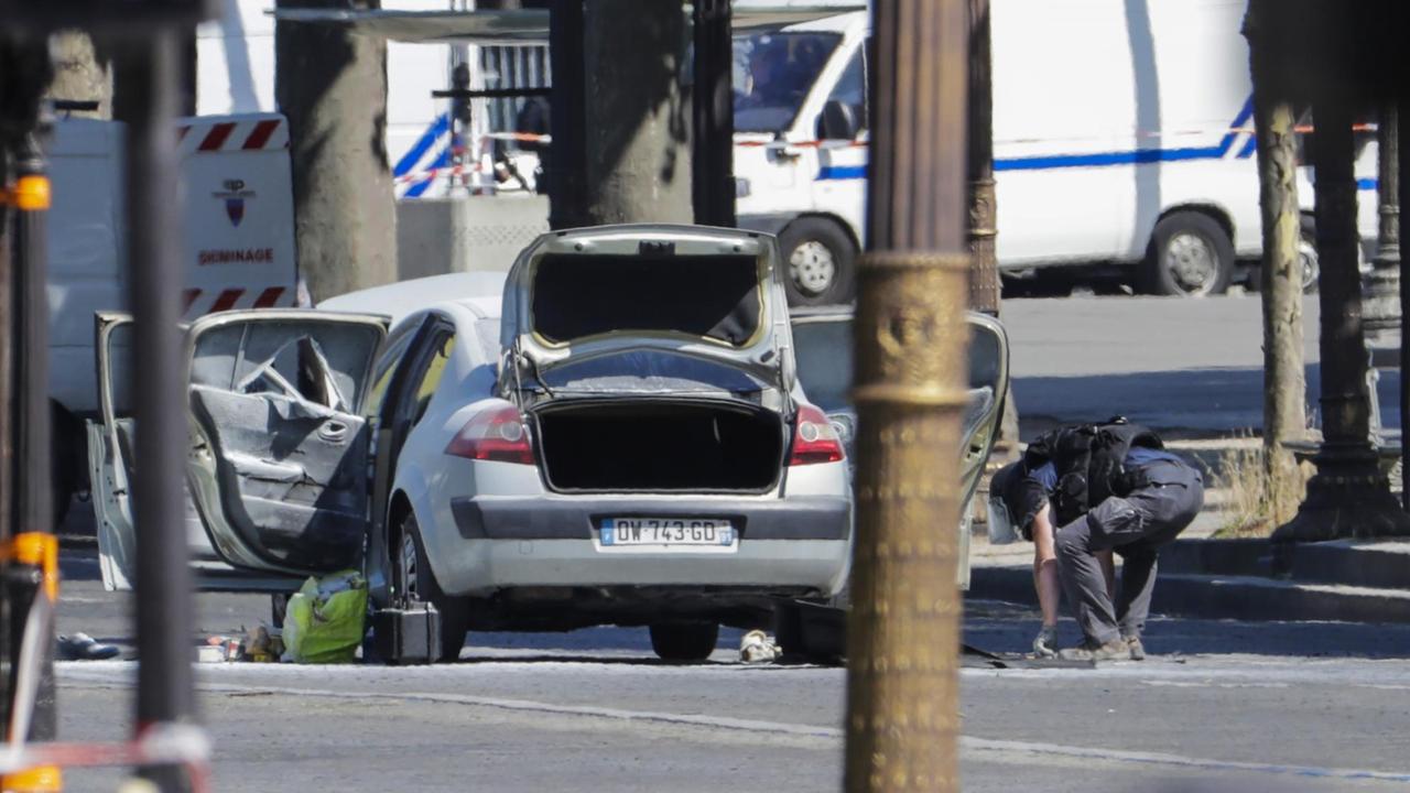 Ein Polizist überprüft das Auto eines Mannes, der auf den Pariser Champs-Elysees einen Polizeiwagen gerammt hat.
