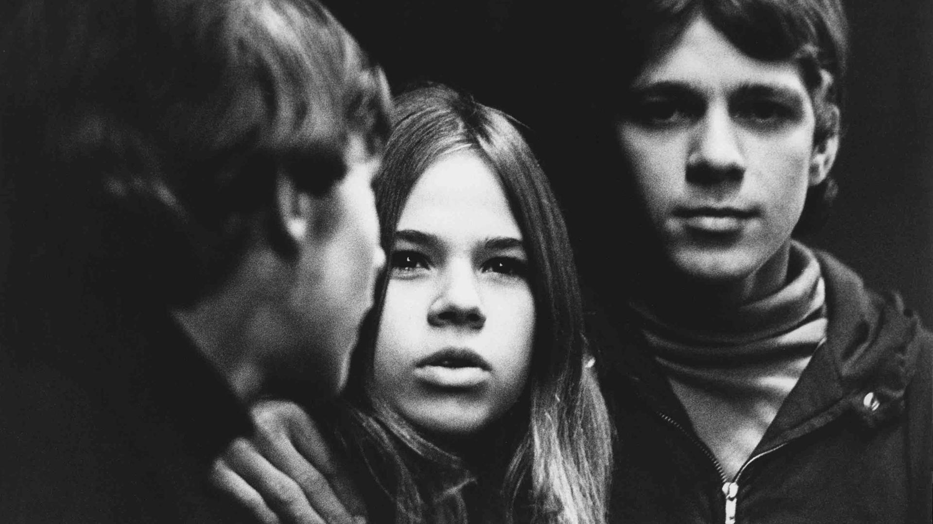 Das Schwarz-Weiß-Foto zeigt die Gesichter von drei jungen Menschen.