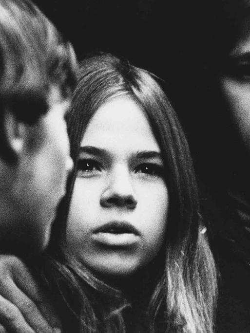 Das Schwarz-Weiß-Foto zeigt die Gesichter von drei jungen Menschen.