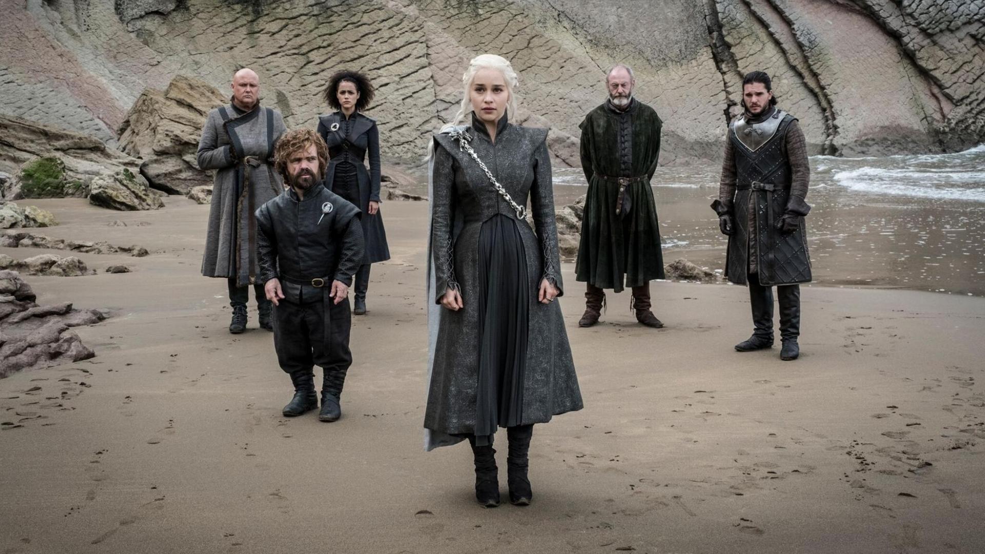 Sechs Charaktere aus "Game of Thrones" stehen am Strand und schauen ernst