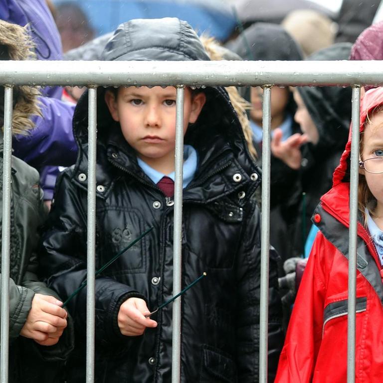 Kinder im Regen vor einer Community Academy im Nordwesten Englands