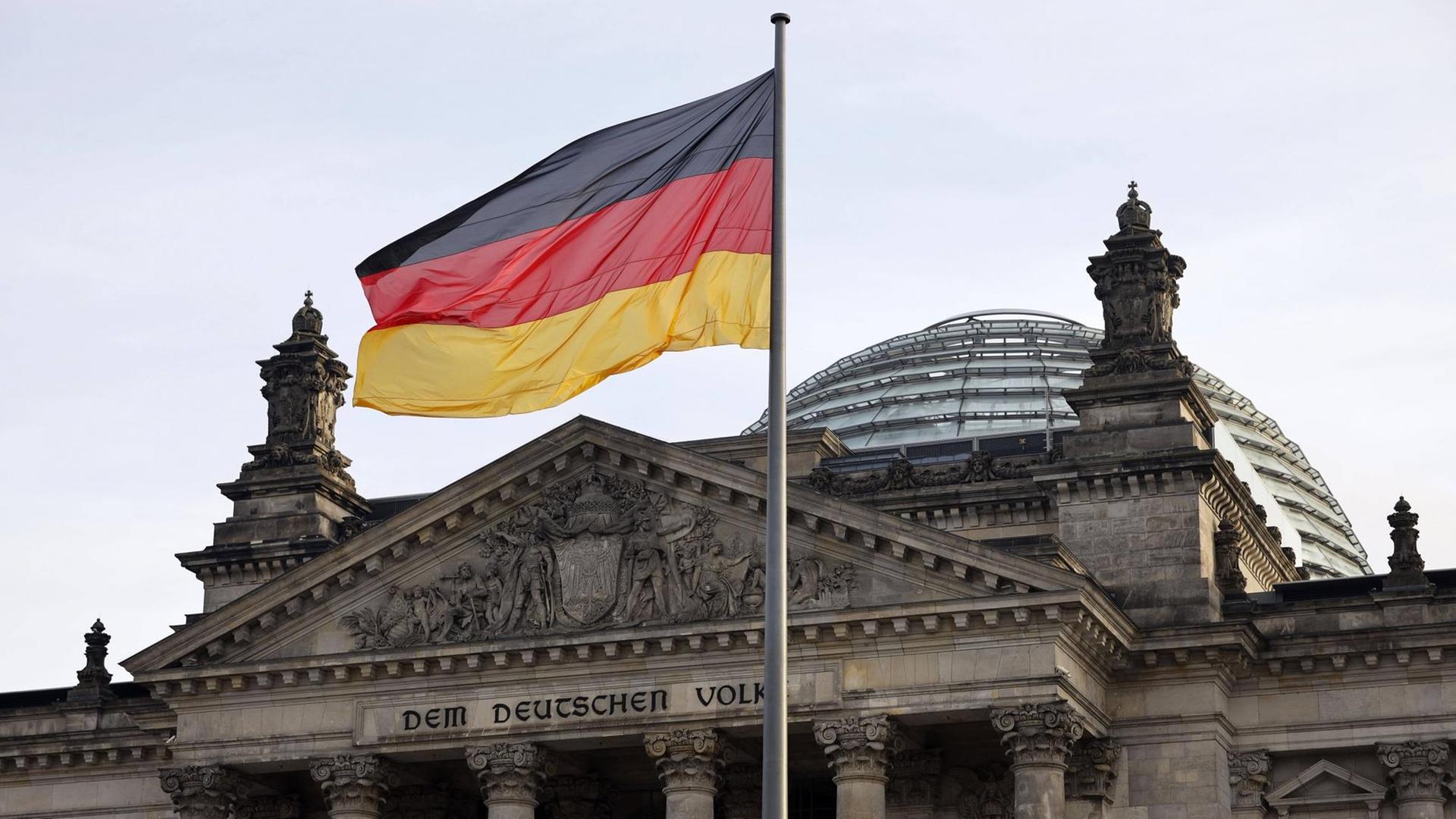 Wehende Deutschlandflagge vor dem Reichstagsgebäude.