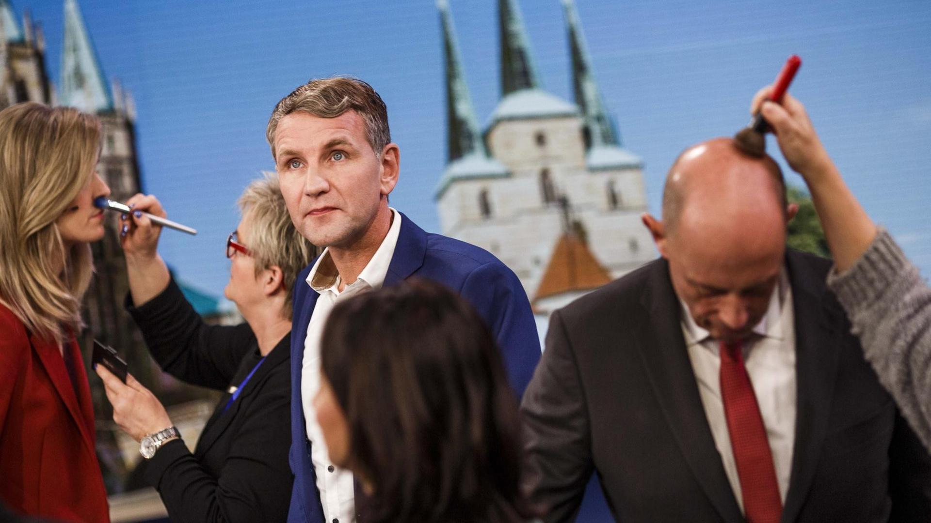  Björn Höcke von der rechten Alternative für Deutschland (AfD) kommt nach der Landtagswahl in Thüringen am 27. Oktober 2019 in Erfurt zu einem Fernsehinterview ins Studio, während weitere Gäste bereits von der Maske abgepinselt werden.