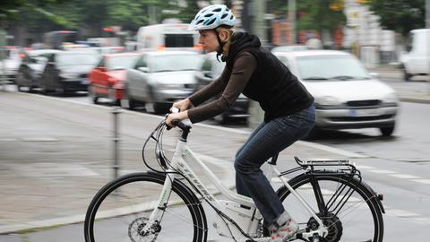 Eine Frau bewegt ein Elektrofahrrad durch Berlin. Die Deutschen nutzen zum Beispiel auf dem Weg zur Arbeit immer häufiger Elektrofahrräder.