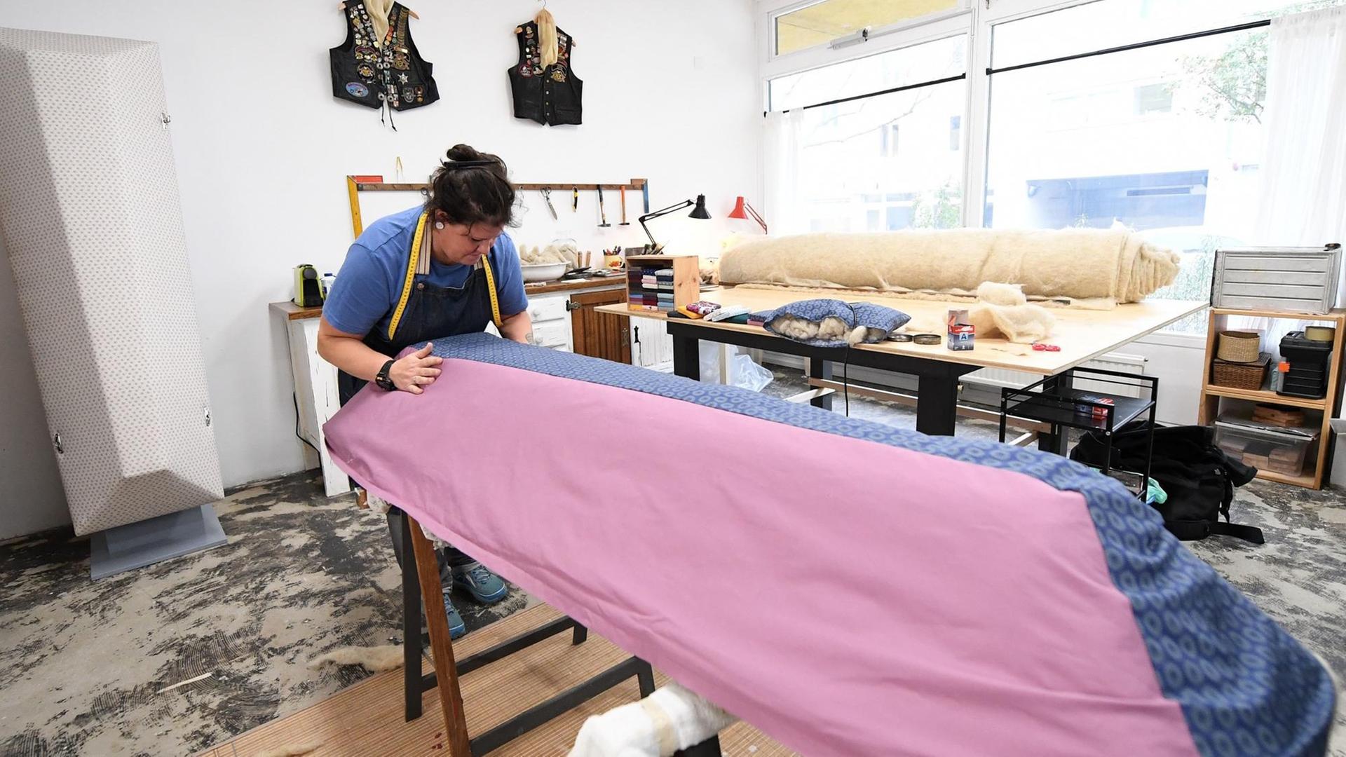 Romana Maschek, Gründerin des Sargateliers, arbeitet an einem neuen Modell mit rosa-blauem Stoffüberzug.