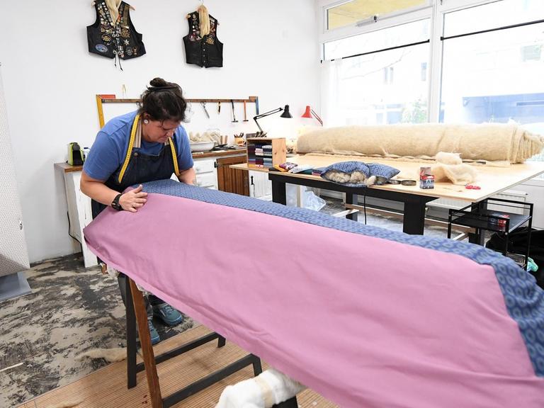 Romana Maschek, Gründerin des Sargateliers, arbeitet an einem neuen Modell mit rosa-blauem Stoffüberzug.