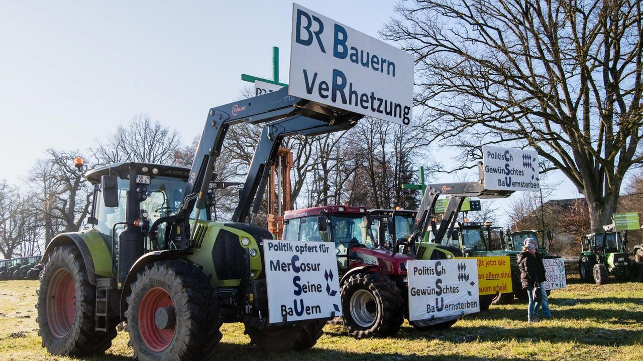 An einem Traktor haben Bauern Schilder angebracht, auf denen steht: "BR Bauern Verhetzung" und "Politik opfert für Mercosur seine Bauern".