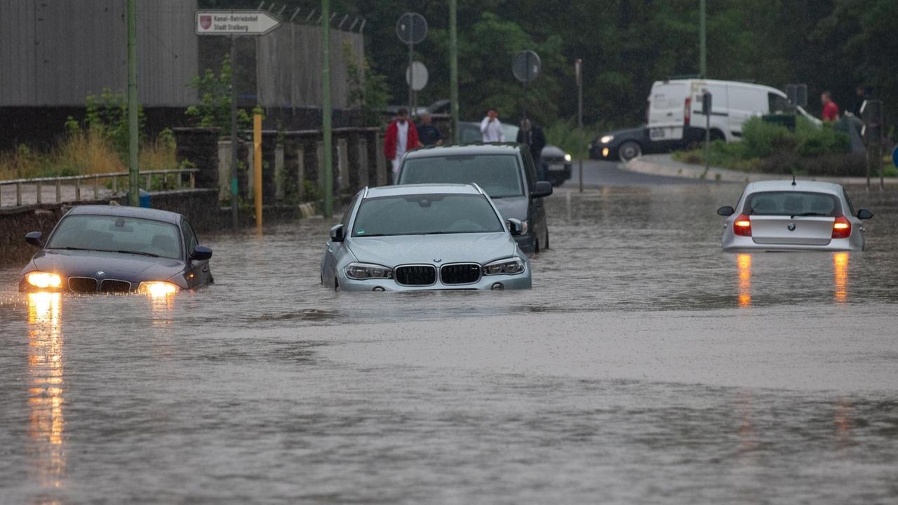 Mehrere Autos stecken nach Starkregen auf einer überfluteten Straße fest. Der Bach Vicht war über die Ufer getreten, das Gelände war überschwemmt.