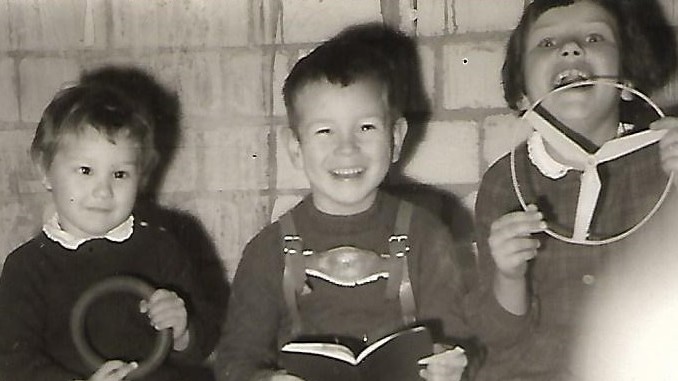 Günther Wessel (M) als Kind. Drei Kinder sitzen in einer Garage und spielen Autofahren.