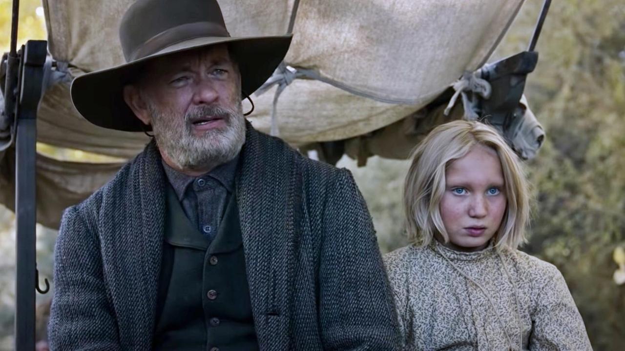Szene aus dem Western „Neues aus der Welt“ von Paul Greengrass. Tom Hanks und Helena Zengel sitzen auf einer Kutsche und blicken nach vorn.