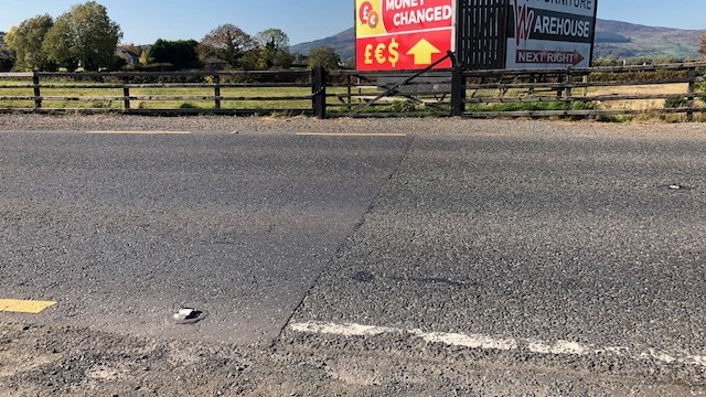 Auf einer Landstraße zwischen Newry und Dundalk deutet nur die Farbe der Straßenmarkierung darauf hin, auf welcher Seite der inneririschen Grenze man sich befindet. Orange im Norden, weiß in der Republik Irland.