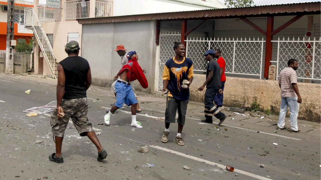 Demonstraten werfen Steine auf Polizisten in der Nähe von Barrikaden in Saint Rose, Guadeloupe.