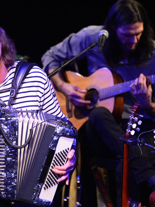 Hans Eckhardt Wenzel spielt Akkordeon, im Hintergrund spielt ein Gitarrist seiner Band