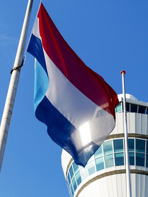 Die niederländische Flagge weht auf Halbmast vor dem Tower des Flughafens Schiphol bei Amsterdam am 23.07.2014.