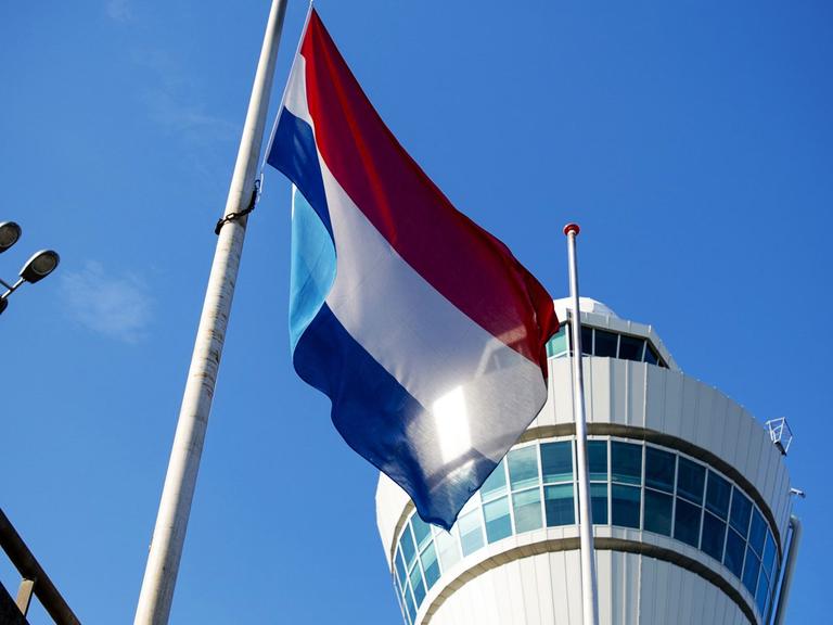 Die niederländische Flagge weht auf Halbmast vor dem Tower des Flughafens Schiphol bei Amsterdam am 23.07.2014.