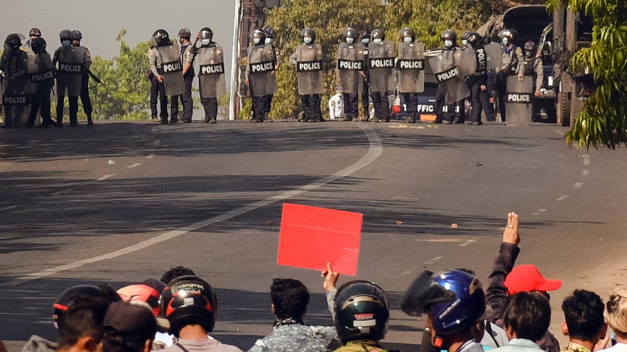 In Bago in Myanmar stehen sich am 8. März 2021 Polizei und Demonstranten auf einer Straße gegenüber.