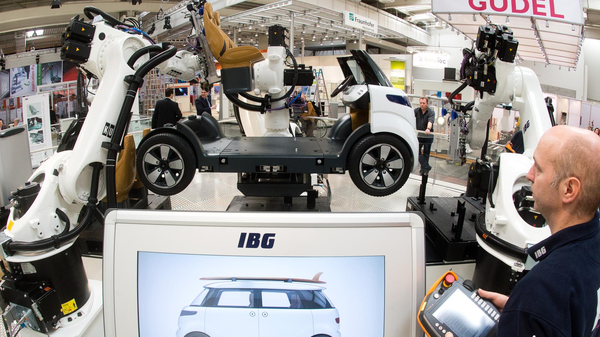 Ein Ingenieur bedient auf der Hannover Messe eine vollautomatische Montagezelle.