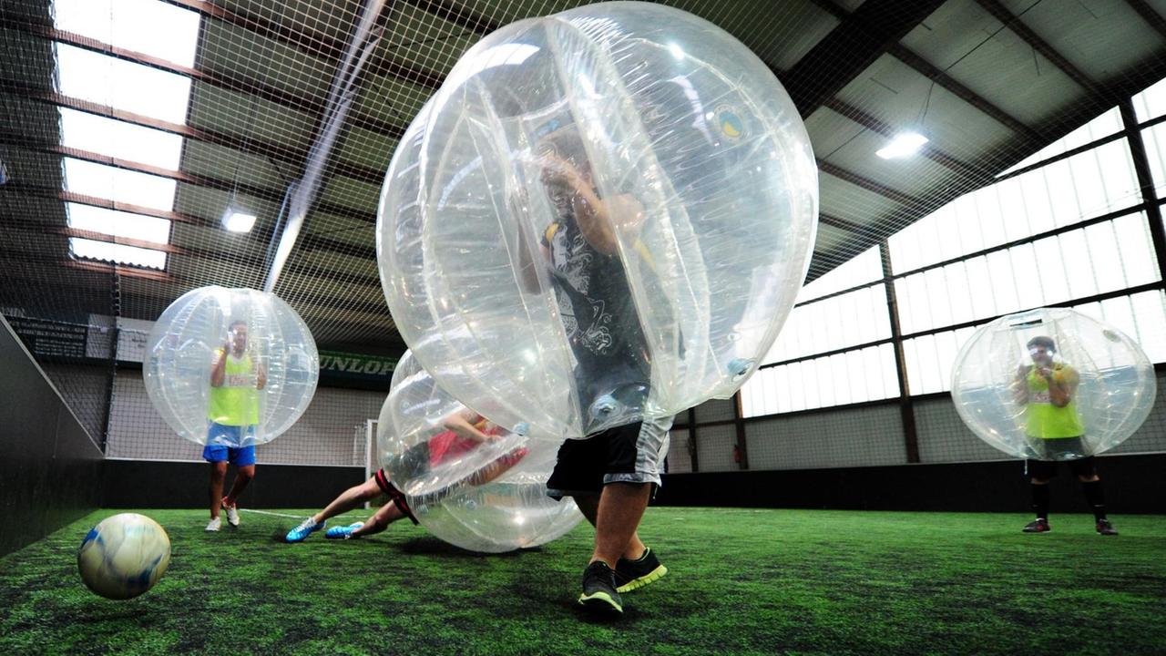 Bubble-Fußballer kämpfen um den Ball.