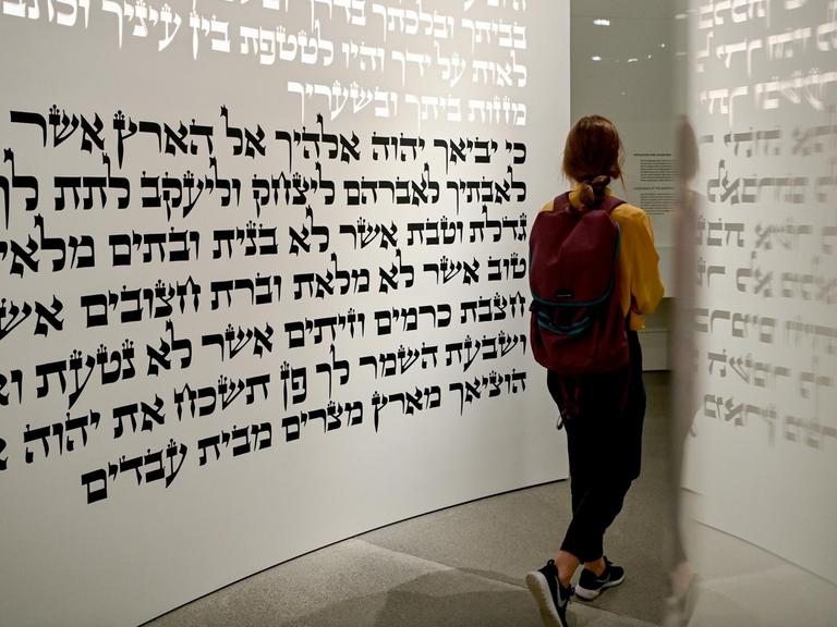 Eine junge Frau geht in der neuen Dauerausstellung «Jüdische Geschichte und Gegenwart in Deutschland» im Liebeskind-Bau des Jüdischen Museums durch den Themenraum «Tora».