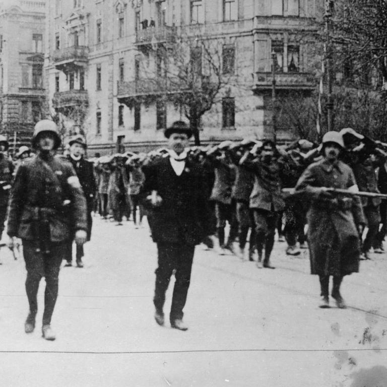 Freikorps ziehen mit Gefangenen durch die Münchner Straßen.