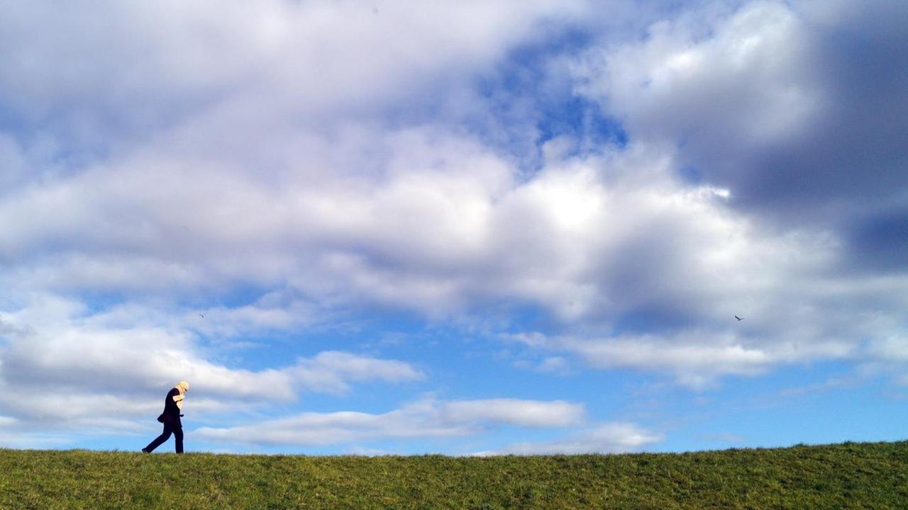 Eine Urlauberin geht am Mittwoch (04.04.2012) bei Wyk auf Föhr auf einem Deich spazieren.
