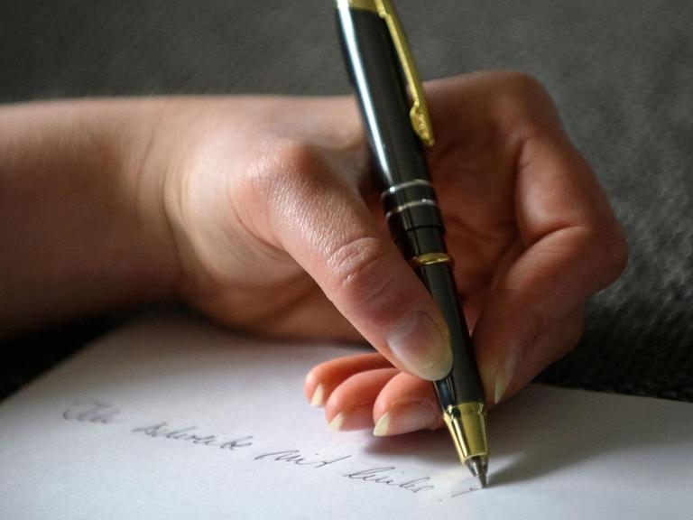 Die Hand einer Frau mit Kugelschreiber setzt ein Ausrufezeichen hinter den Satz: "Ich schreibe mit links".