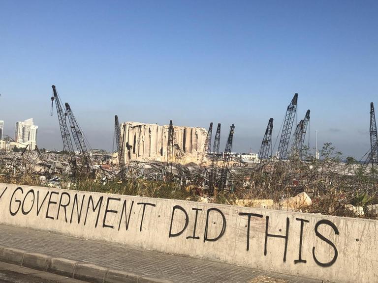 "Meine Regierung hat das gemacht", steht am Straßenrand vor der Ruine des Lagerhauses in Beirut, das Anfang August 2020 explodierte