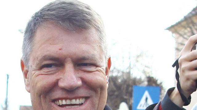Der siegreiche Präsidentschaftskandidat Klaus Johannis verlässt mit seiner Frau ein Wahllokal und ist dabei umringt von Fotografen.