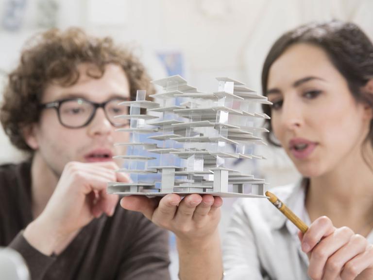 Zwei junge Architekten betrachten ein Modell